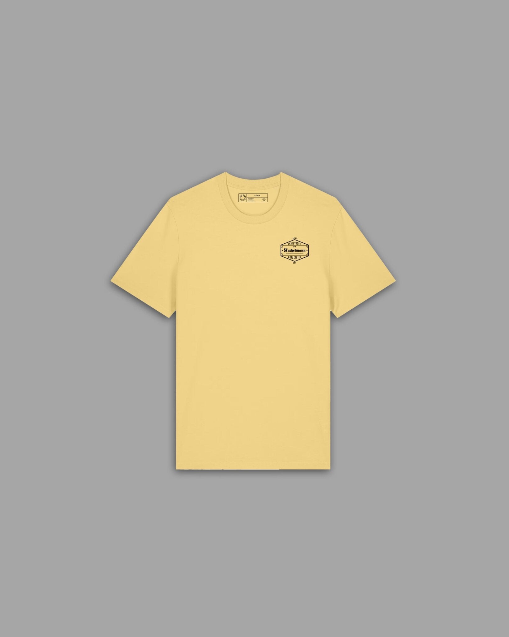 Skate'n'Rock Kachelmann T-Shirt Vorderseite in Pastellgelb mit dunklem hexagonalem Kachelmann Brustlogo – Skateboard Mode