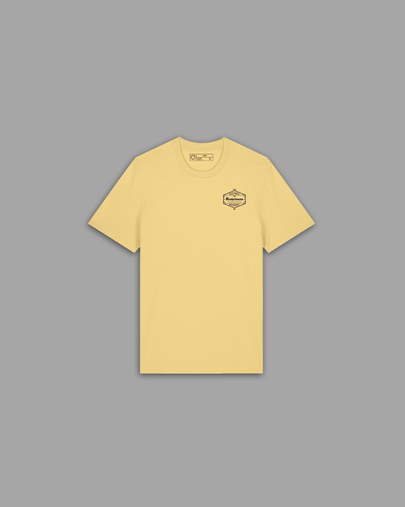 Skate'n'Rock Kachelmann T-Shirt Vorderseite in Pastellgelb mit dunklem hexagonalem Kachelmann Brustlogo – Skateboard Mode