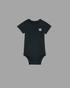 Schwarzer Baby Body von Back To The Streets, Vorderansicht mit kleinem weißem Skate. Rock. Love. Brustprint, Druckknöpfe an Schulter und Schritt.
